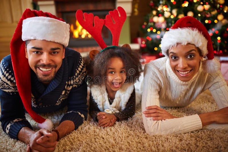 Famiglia afroamericana felice con i cappelli di Santa immagine stock
