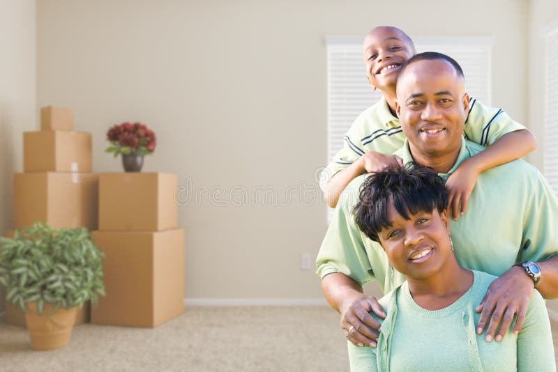 Famiglia afroamericana nella sala con le scatole commoventi imballate fotografia stock libera da diritti Famiglia afroamericana nella sala con le scatole commoventi imballate fotografia stock libera da diritti