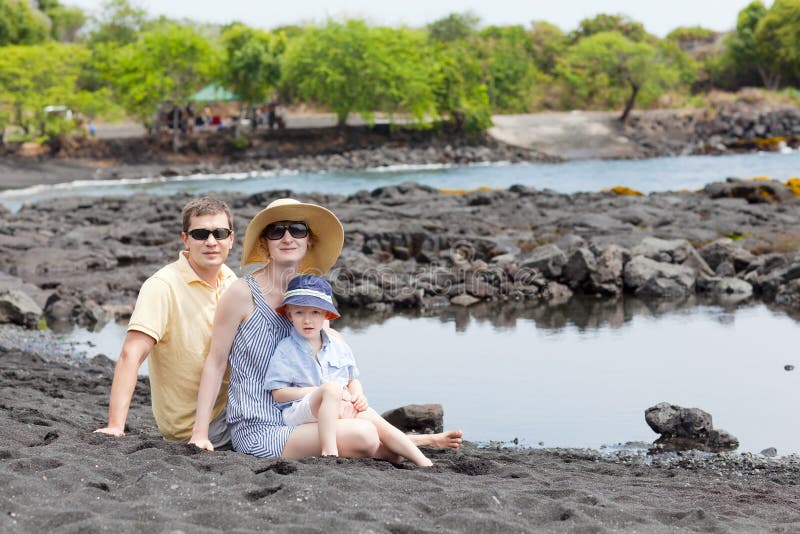 Famiglia alla spiaggia nera della sabbia fotografia stock Famiglia alla spiaggia nera della sabbia fotografia stock