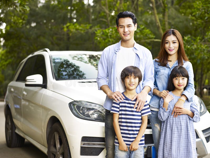 Asian family with two children taking a photo during travel by car. Asian family with two children taking a photo during travel by car.