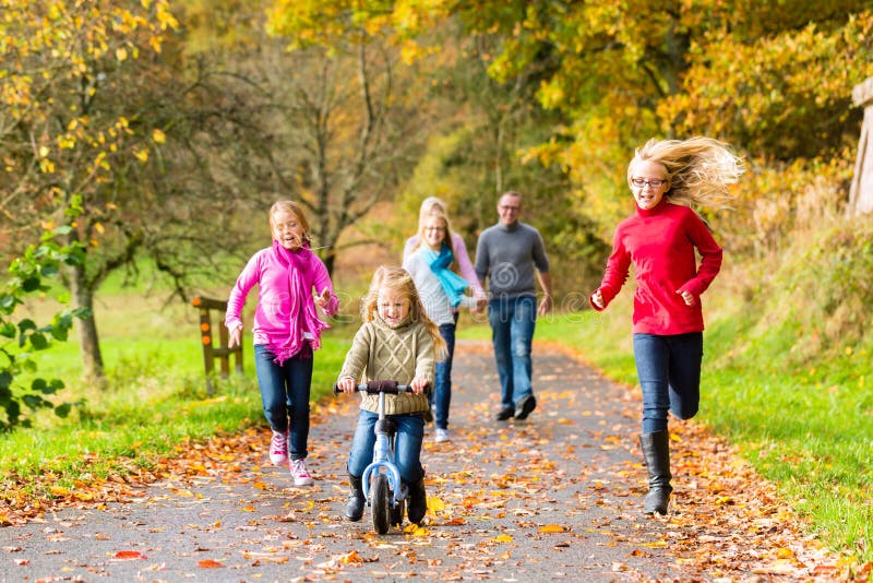 Famiglia che fa passeggiata nella foresta di caduta di autunno fotografie stock Famiglia che fa passeggiata nella foresta di caduta di autunno fotografie stock