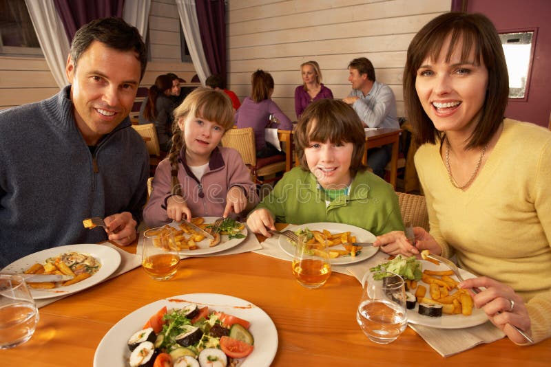 Famiglia che mangia insieme pranzo nel ristorante fotografia stock