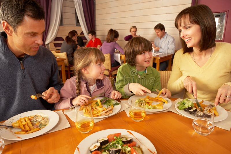 Famiglia che mangia insieme pranzo nel ristorante immagini stock libere da diritti