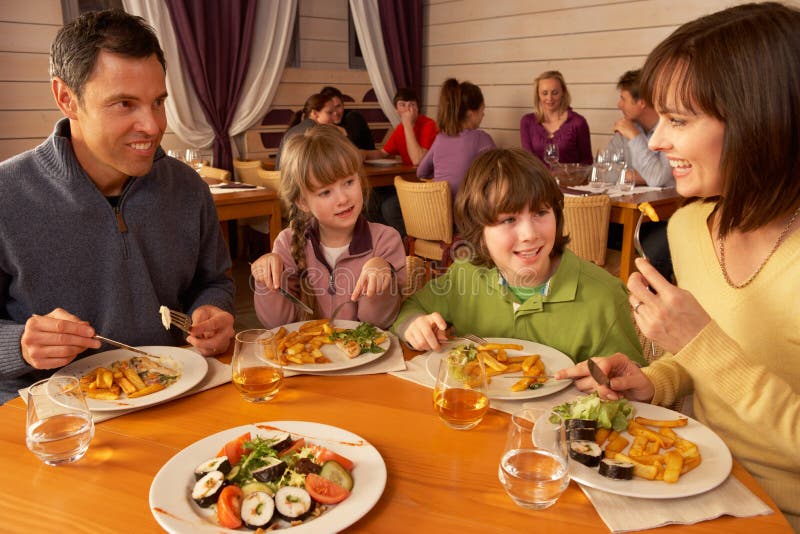 Famiglia che mangia insieme pranzo nel ristorante fotografia stock libera da diritti