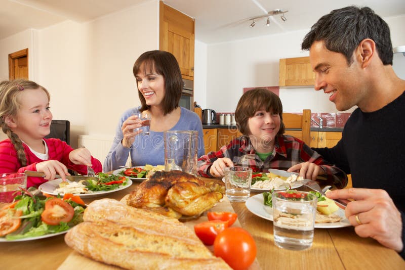 Famiglia che mangia insieme pranzo nella cucina fotografia stock libera da diritti
