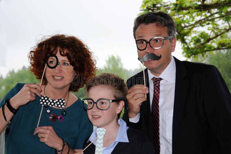 Famiglia che posa davanti ad una cabina della foto fotografia stock Famiglia che posa davanti ad una cabina della foto fotografia stock