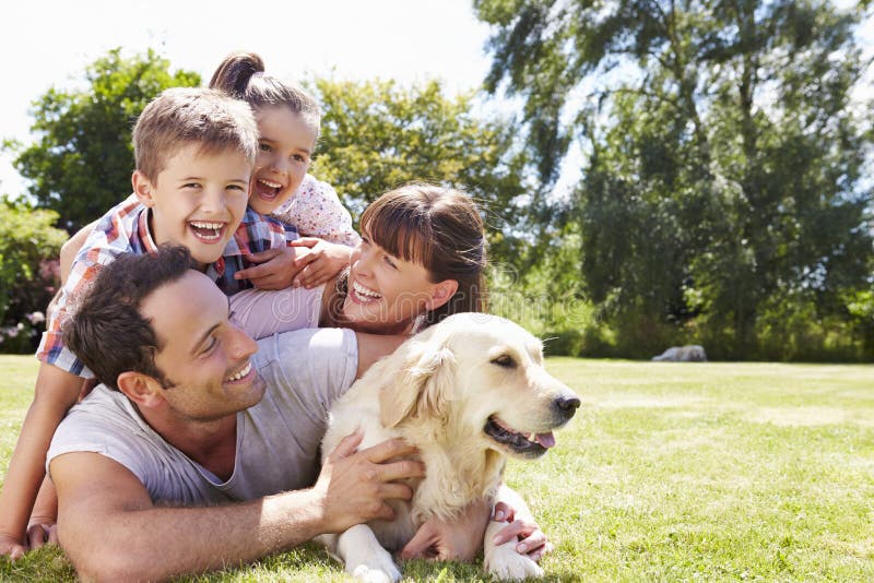 Family Relaxing In Garden With Pet Dog. Family Relaxing In Garden With Pet Dog