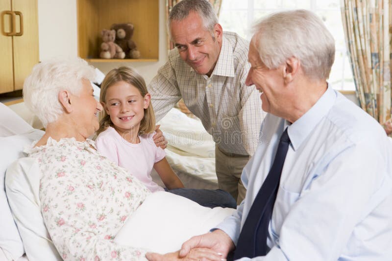 Famiglia che si siede con la donna maggiore in ospedale immagini stock Famiglia che si siede con la donna maggiore in ospedale immagini stock