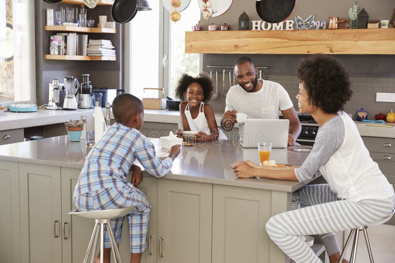 Family Sitting In Kitchen Enjoying Morning Breakfast Together. Family Sitting In Kitchen Enjoying Morning Breakfast Together