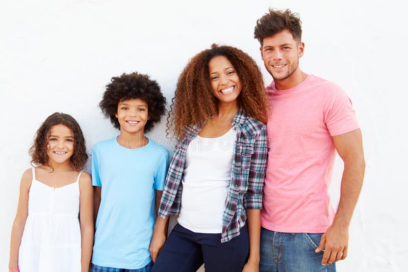 Famiglia che sta all'aperto contro il ½ bianco del ¿ di Wallï immagine stock libera da diritti Famiglia che sta all'aperto contro il ½ bianco del ¿ di Wallï immagine stock libera da diritti