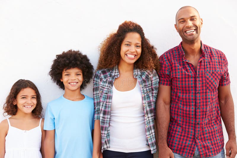 Famiglia che sta all'aperto contro il ½ bianco del ¿ di Wallï fotografia stock Famiglia che sta all'aperto contro il ½ bianco del ¿ di Wallï fotografia stock