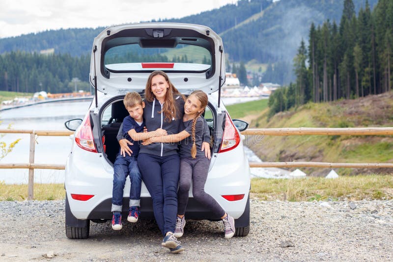 Famiglia che viaggia in macchina e che si diverte sul parcheggio immagini stock libere da diritti Famiglia che viaggia in macchina e che si diverte sul parcheggio immagini stock libere da diritti