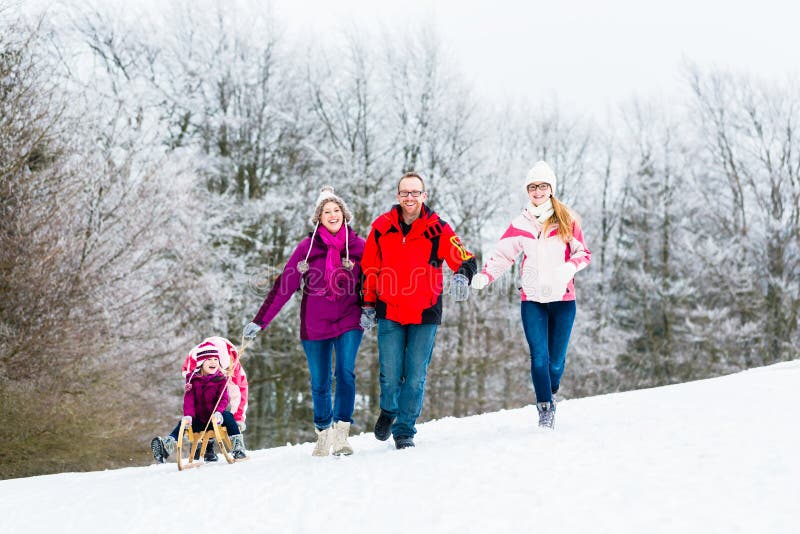 Famiglia con i bambini che hanno passeggiata di inverno in neve fotografia stock libera da diritti Famiglia con i bambini che hanno passeggiata di inverno in neve fotografia stock libera da diritti