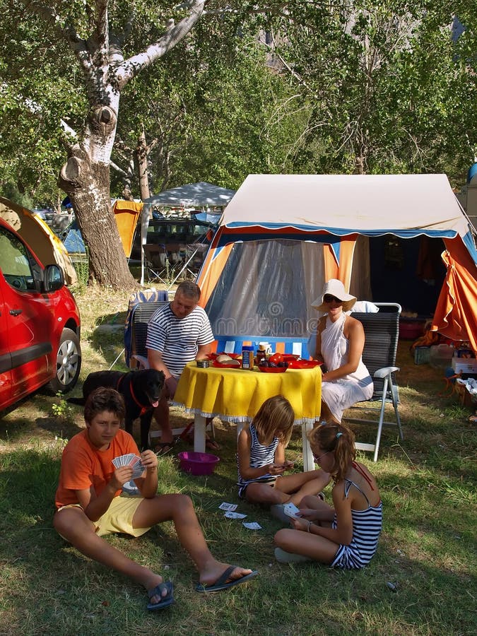 Family with dog on enjoying at summer vacation at a camp in early morning. Vertical color photo. Family with dog on enjoying at summer vacation at a camp in early morning. Vertical color photo.