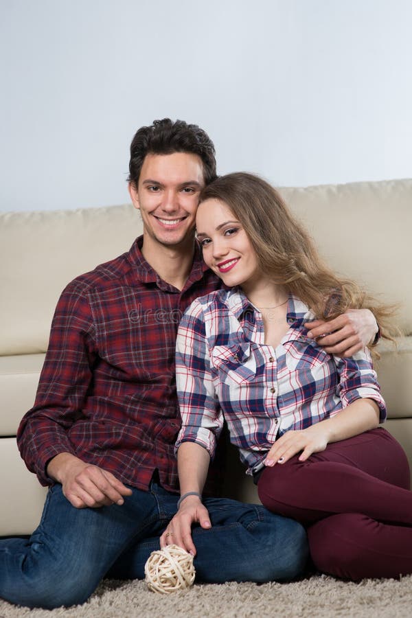 Famiglia con un bambino in una stanza con un sofà fotografia stock Famiglia con un bambino in una stanza con un sofà fotografia stock
