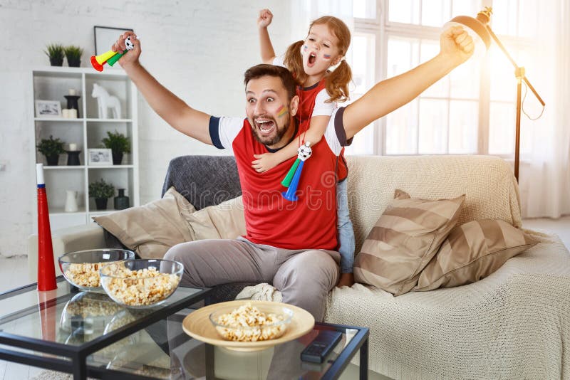 Famiglia dei fan che guarda una partita di calcio sulla TV a casa fotografia stock libera da diritti Famiglia dei fan che guarda una partita di calcio sulla TV a casa fotografia stock libera da diritti