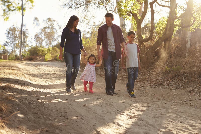 Famiglia della corsa mista che cammina sul percorso rurale, vista frontale immagini stock Famiglia della corsa mista che cammina sul percorso rurale, vista frontale immagini stock