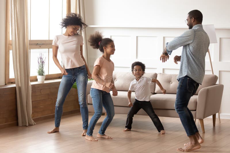 Famiglia di quattro africana attiva divertente felice che balla a casa