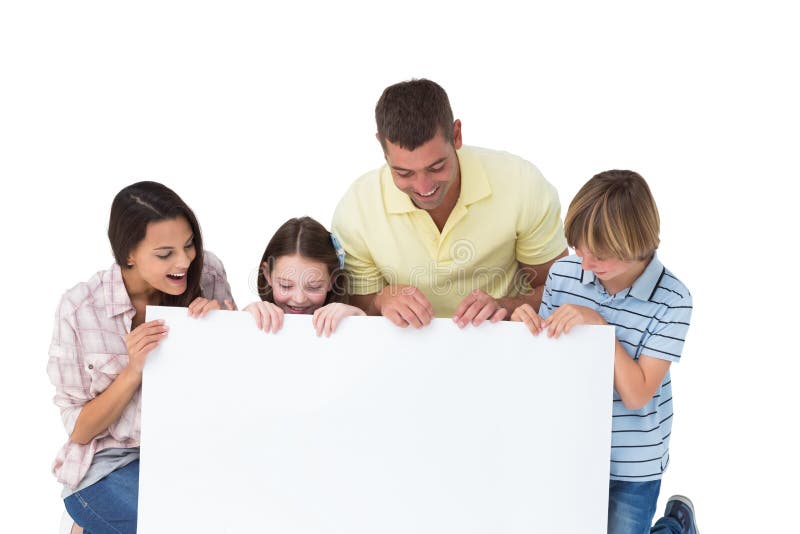 Famiglia di quattro che esamina tabellone per le affissioni fotografia stock Famiglia di quattro che esamina tabellone per le affissioni fotografia stock