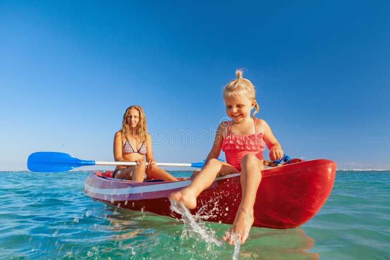 Happy family - young mother, children have fun on boat walk. Woman and child paddling on kayak. Travel lifestyle, parents with kids recreational activity, watersports on summer sea beach vacation. Happy family - young mother, children have fun on boat walk. Woman and child paddling on kayak. Travel lifestyle, parents with kids recreational activity, watersports on summer sea beach vacation