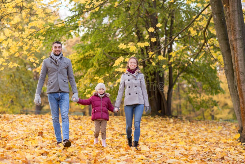 Famiglia felice che cammina al parco di autunno fotografia stock Famiglia felice che cammina al parco di autunno fotografia stock