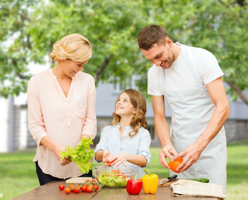 Famiglia felice che cucina insalata di verdure per la cena