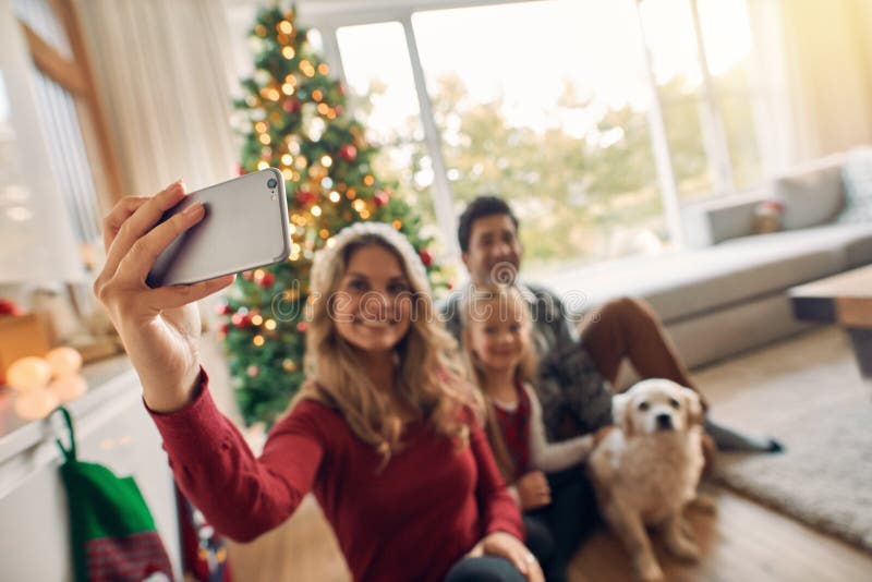 Famiglia felice che prende autoritratto durante il Natale a casa immagini stock Famiglia felice che prende autoritratto durante il Natale a casa immagini stock