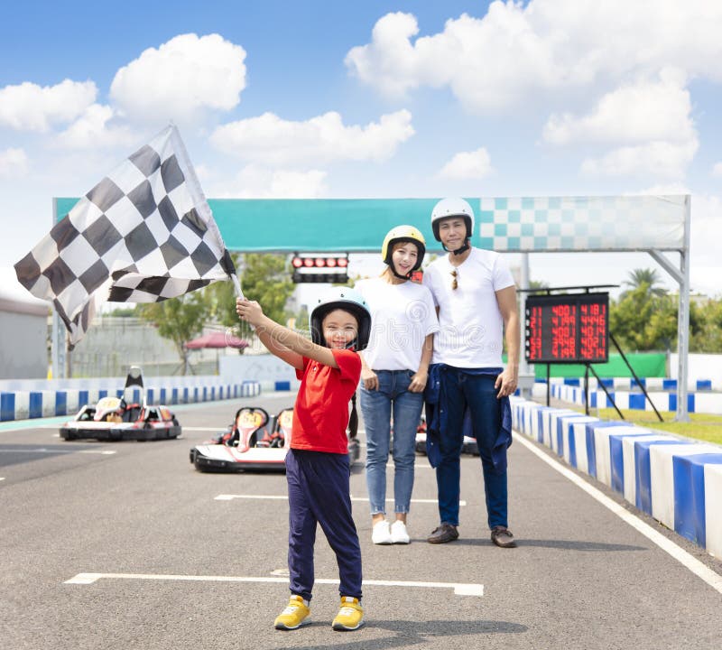 Famiglia felice che sta in movimento la pista di corsa del kart fotografia stock libera da diritti Famiglia felice che sta in movimento la pista di corsa del kart fotografia stock libera da diritti