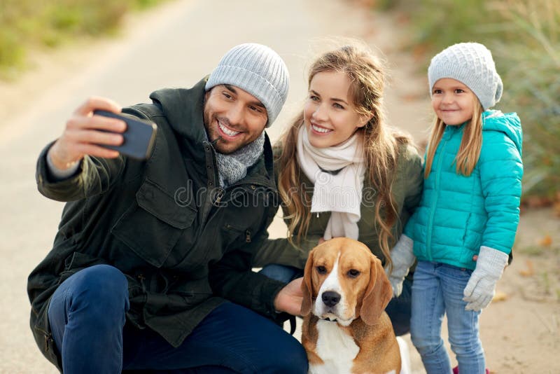Famiglia felice con il cane che prende selfie in autunno fotografie stock Famiglia felice con il cane che prende selfie in autunno fotografie stock