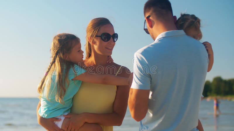 Famiglia felice con le figlie in spiaggia d'estate archivi video