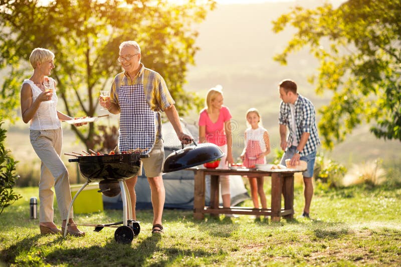 Happy generation family having a barbecue party on camping. Happy generation family having a barbecue party on camping