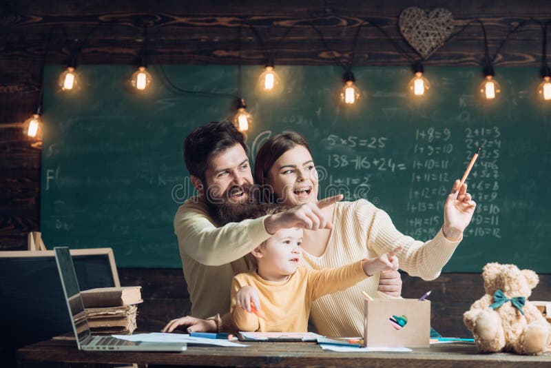 Famiglia felice La famiglia felice ha ottenuto l'idea luminosa Dita felici di sorriso e del punto della famiglia nella classe Fam fotografie stock libere da diritti Famiglia felice La famiglia felice ha ottenuto l'idea luminosa Dita felici di sorriso e del punto della famiglia nella classe Fam fotografie stock libere da diritti