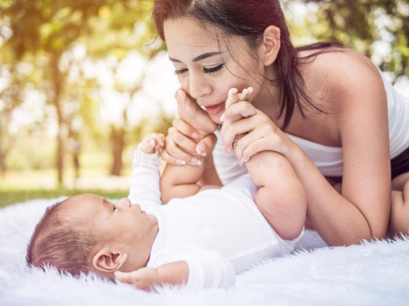 Famiglia felice, madre e piccolo bambino ridenti e giocanti di estate nel parco fotografia stock libera da diritti Famiglia felice, madre e piccolo bambino ridenti e giocanti di estate nel parco fotografia stock libera da diritti