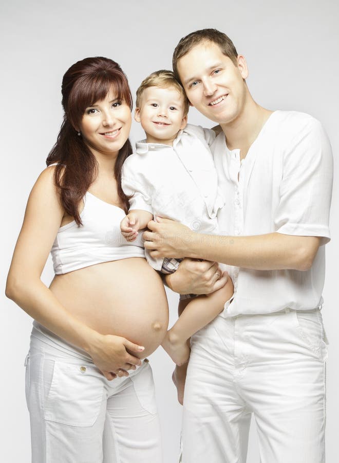 Famiglia felice, padre incinto della madre e bambino nel bianco fotografie stock Famiglia felice, padre incinto della madre e bambino nel bianco fotografie stock