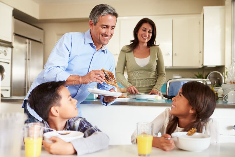 Famiglia ispana che mangia prima colazione a casa insieme