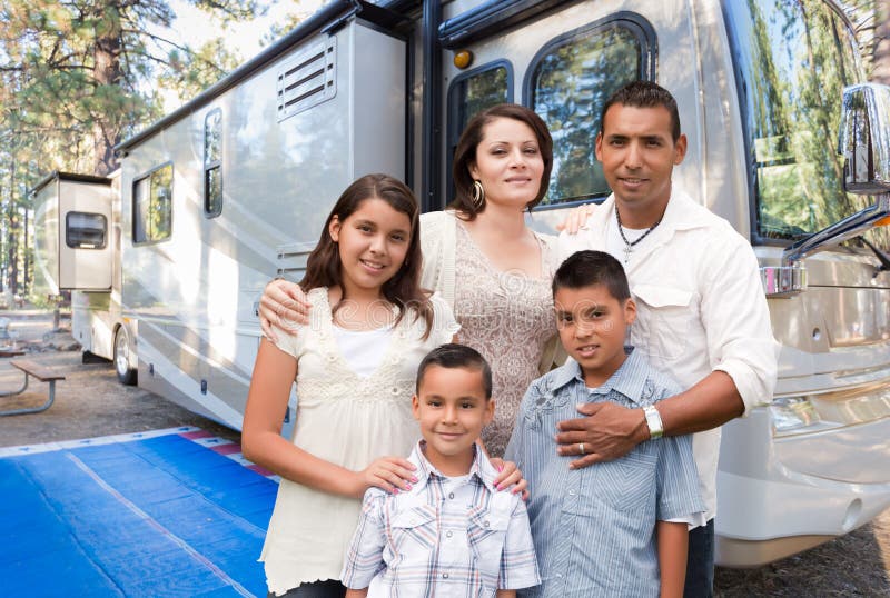 Happy Hispanic Family In Front of Their Beautiful RV At The Campground. Happy Hispanic Family In Front of Their Beautiful RV At The Campground.