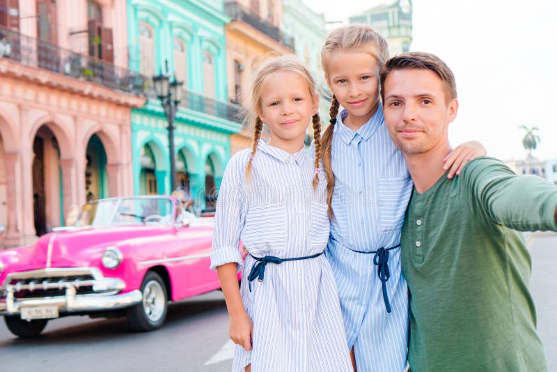 Famiglia nell'area popolare a vecchia Avana, Cuba Un ritratto di due bambini e di giovane aria aperta del papà su una via di Avan