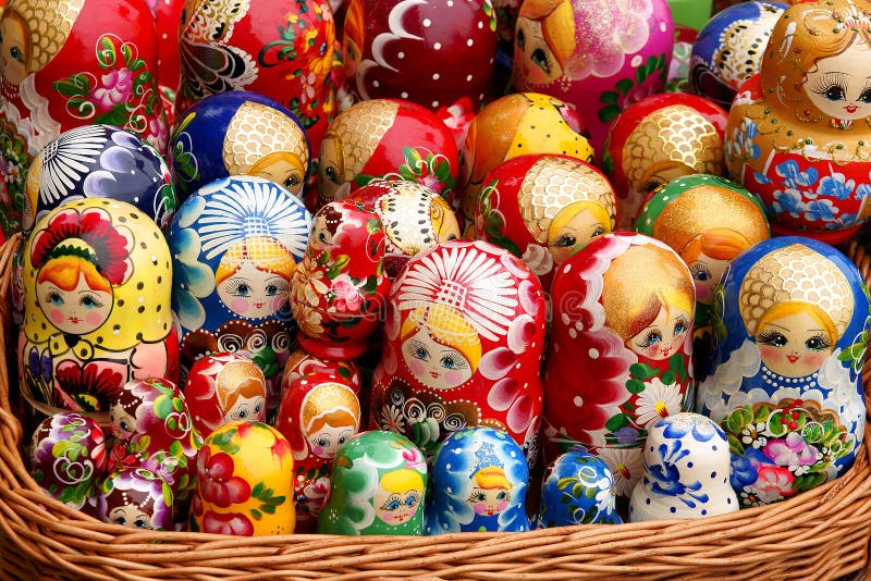 Unique wooden Russian Matryoshka dolls in different color shades in a wicker basket like one big family. Unique wooden Russian Matryoshka dolls in different color shades in a wicker basket like one big family