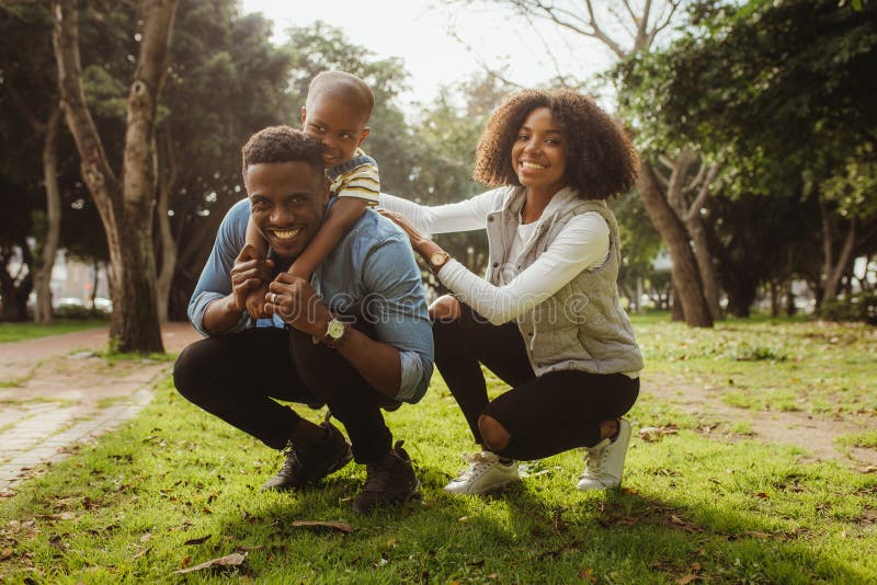 Familia africana feliz que goza en el parque foto de archivo