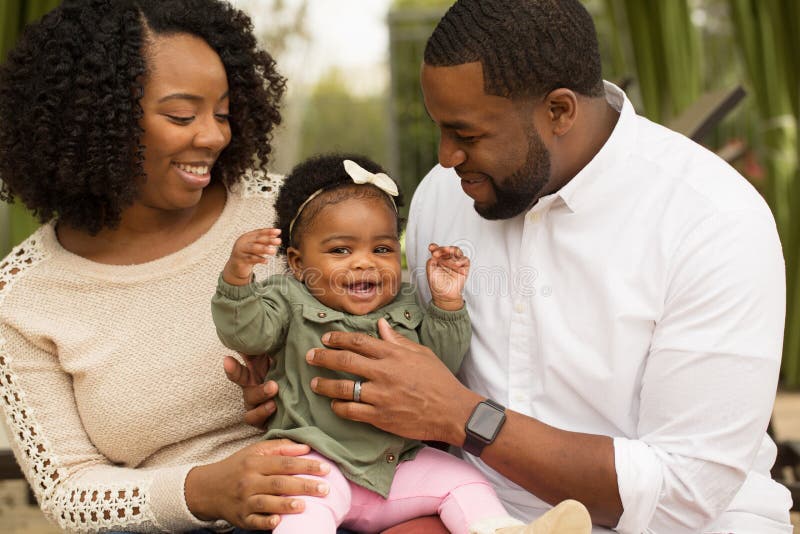Familia afroamericana feliz con su bebé imagen de archivo