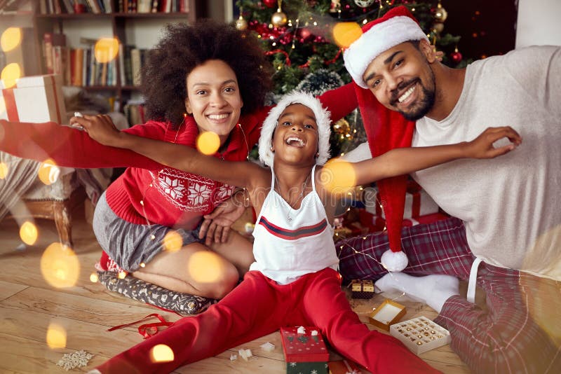 Familia afroamericana feliz delante del árbol de navidad imagen de archivo