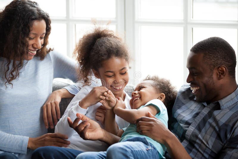 Familia afroamericana feliz que juega con los niños en casa imágenes de archivo libres de regalías