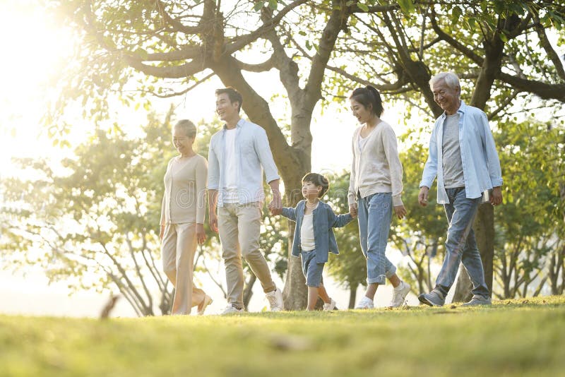 Familia asiática de tres generaciones caminando por el parque
