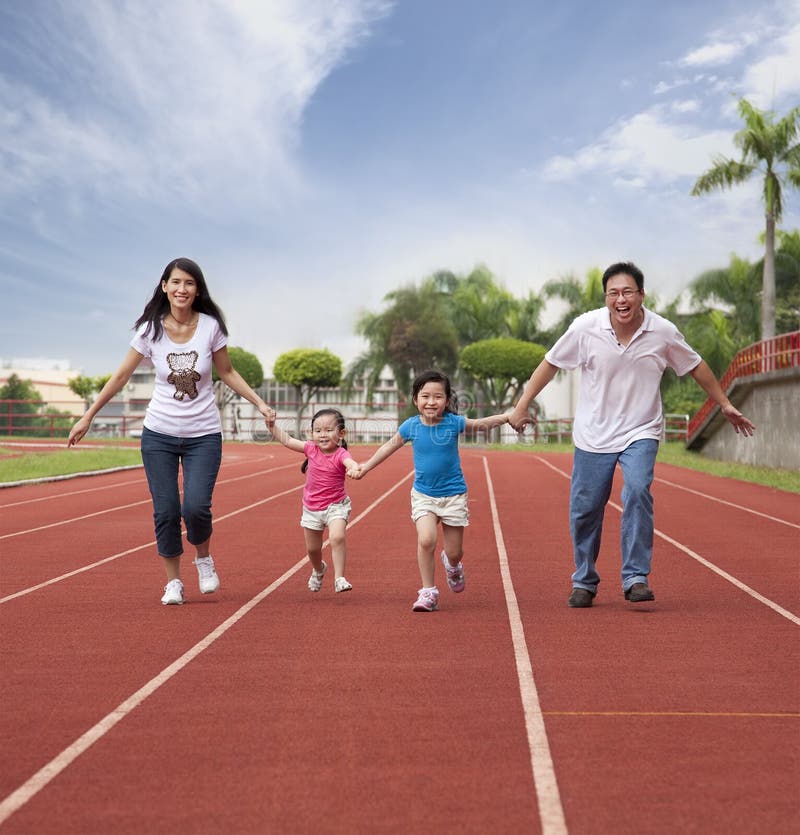 Familia asiática feliz que se ejecuta junto imágenes de archivo libres de regalías Familia asiática feliz que se ejecuta junto imágenes de archivo libres de regalías