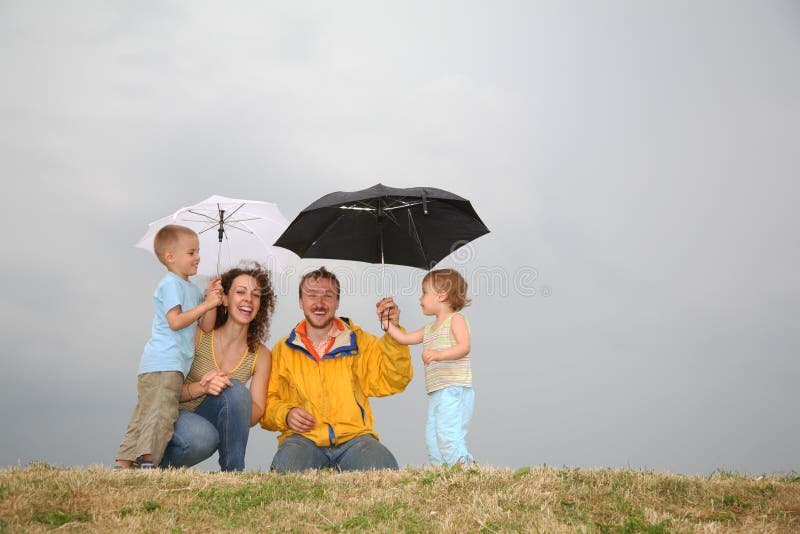Familia bajo los paraguas archivo. Imagen tenencia -