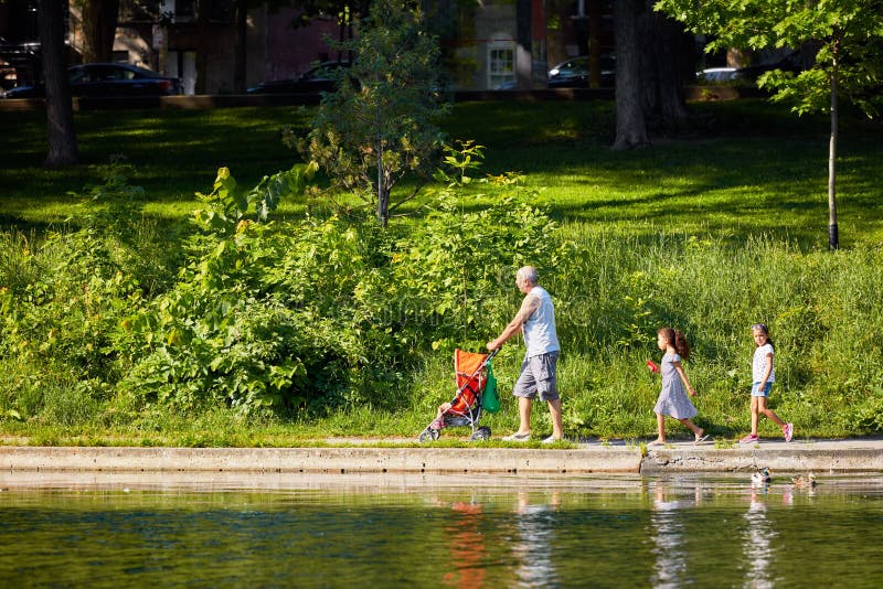 Familia canadiense que camina cerca de la charca en el parque de Fontaine del La, Montreal, Canadá foto de archivo libre de regalías Familia canadiense que camina cerca de la charca en el parque de Fontaine del La, Montreal, Canadá foto de archivo libre de regalías