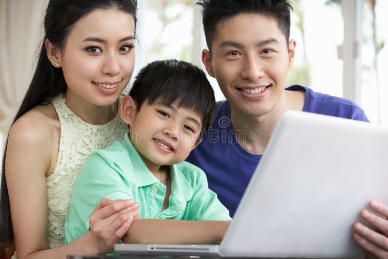 Familia china que se sienta usando la computadora portátil en el país fotos de archivo libres de regalías Familia china que se sienta usando la computadora portátil en el país fotos de archivo libres de regalías