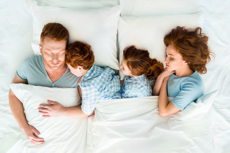 Familia con dos niños que duermen junto imagen de archivo