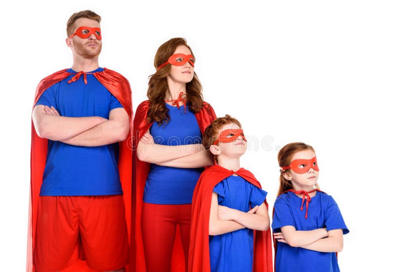 familia confiada de super héroes en los trajes que se colocan con los brazos cruzados y que miran lejos imagenes de archivo familia confiada de super héroes en los trajes que se colocan con los brazos cruzados y que miran lejos imagenes de archivo