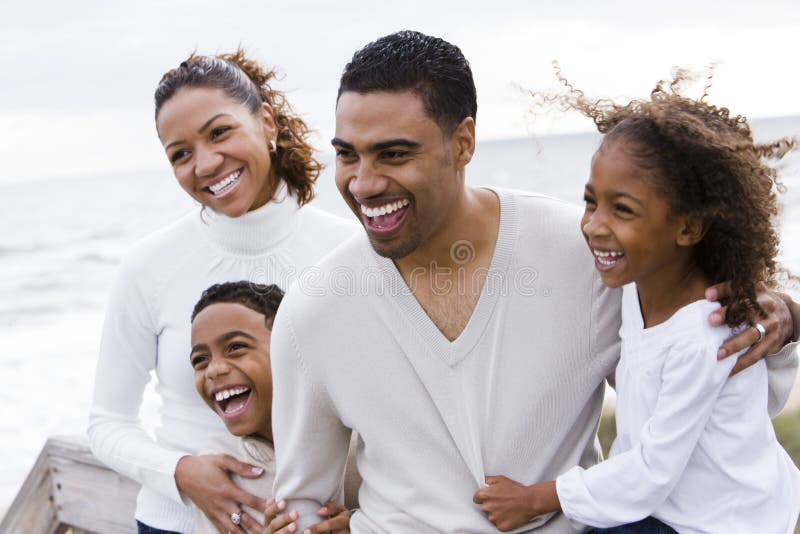 Familia de cuatro miembros feliz del African-American en la playa fotografía de archivo